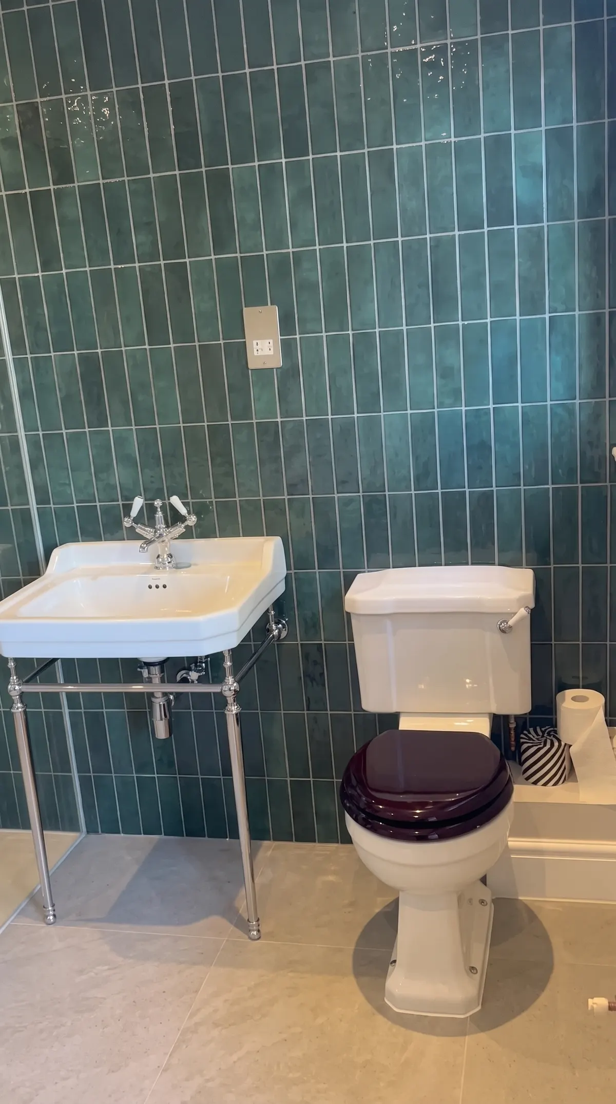 Cloakroom with deep green gloss vertical tiles, a washstand basin and a traditional WC