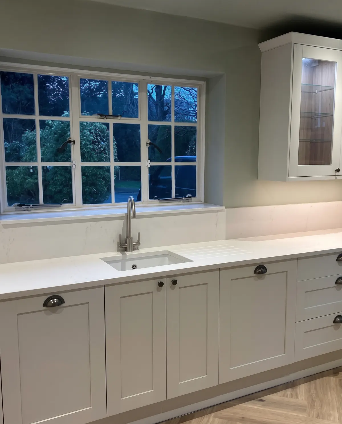 Pale grey shaker kitchen run under a Georgian style window during a whole house renovation